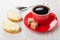 Red cup with coffee, two sandwiches with melted cheese, spoon