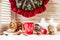 Red cup of hot drink and Christmas cupcake. Composition with Christmas wreath, holly berries, red apple and Christmas decorations