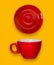 Red cup and a saucer. Coffee set on a yellow background