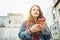 Red curly long hair caucasian teen girl Portrait walking on street and using modern smartphone maps for city streets navigation.