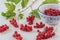 Red currants on a white wooden table and in a blue and white decorated porcelain bowl