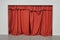 Red curtain closed over large doorway on a white wall