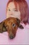 Red dachshund dog in arms of his mistress, teenage girl. Sad eyes, sad. Close-up portrait. Pet love concept