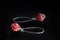 Red dangle earrings made of superduo beads on a dark background