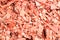 Red decorative chips, wood textured background top view. Shredded tree bark for decorating a garden plot and other surfaces