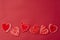 Red decorative hearts over red background. Valentine's Day, love celebration. Copy space. Top view