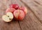 Red delicious apples and freshly sliced apple pieces on rustic wooden table   - close up