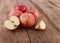 Red delicious apples and freshly sliced apple pieces on rustic wooden table   - close up