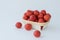 red delicious strawberry in light square wooden plate on white background.