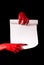 Red devil hands with black nails holding paper scroll
