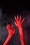 Red devil hands with black sharp nails, extreme body-art