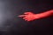 Red devil pointing hand with black sharp nails, ex