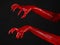 Red Devil\'s hands with black nails, red hands of Satan, Halloween theme, on a black background, isolated