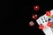 Red dice are put on for the king queen jack of spades playing card in a dark black background