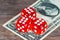 Red dices with one dollar banknote on wooden table