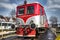 Red diesel locomotive moving on railway.
