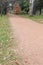 A red dirt walking path in a public park in autumn