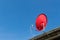 Red dish satellite receiver on roof with blue sky
