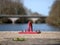 Red docking ring front of bridge on sarthe river