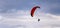 Red dome of a motor paraglider against a blue evening summer sky