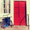 Red door and blue bicycle in old european house, Amsterdam.