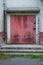 Red door to the utility room for storing equipment of janitors in a five-story city building