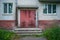 Red door to the utility room for storing equipment of janitors in a five-story city building