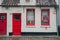 Red door and window with the famous Manneken Pis statue