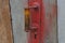 Red doorknob on gray wooden door boards