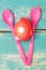 Red dotted easter egg and pink spoons on blue shabby chic background