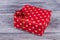 Red dotted gift box on wooden background.