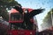 Red double decker bus in Kuala Lumpur, Flamengo fans following their bus. Huge vulture, AI Generated