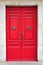 A red double door with lion head brass knockers.