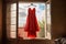 red dress on hanger by a window, natural light