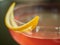 Red drink with a lemon half moon lemon zest decoration close up