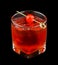 Red drink with a maraschino cherry isolated on black