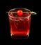 Red drink with a maraschino cherry isolated on black