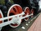 Red driving wheels of a steam locomotive, connected by levers