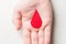 Red drop as symbol of blood in person`s hand. Blood donation concept