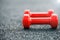 Red dumbbells on a rubberized sports field close-up. Small depth of field, background image