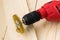 Red electric drill with round metal wire brush for cleaning of metal and wood and remove rust over rough wooden surface.