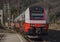 Red electric fast train in Austria Alps mountains