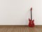 Red electric guitar in a empty room