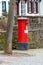 Red english mailbox in front of a stone wall in Bad Muenstereifel