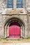 Red entrance archway to the church of Saint-Suliac