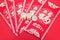 Red envelopes and euro coins on a red background. The Chinese characters in the picture mean `happiness` and `good luck`