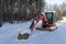 A red excavator covered by snow during a cold winter day