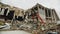 Red excavator dismantles rubble of abandoned hockey stadium