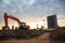 Red excavator during groundwork on construction site. Hydraulic backhoe on earthworks.