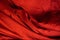 Red fabric. Wrinkled silk bedding.